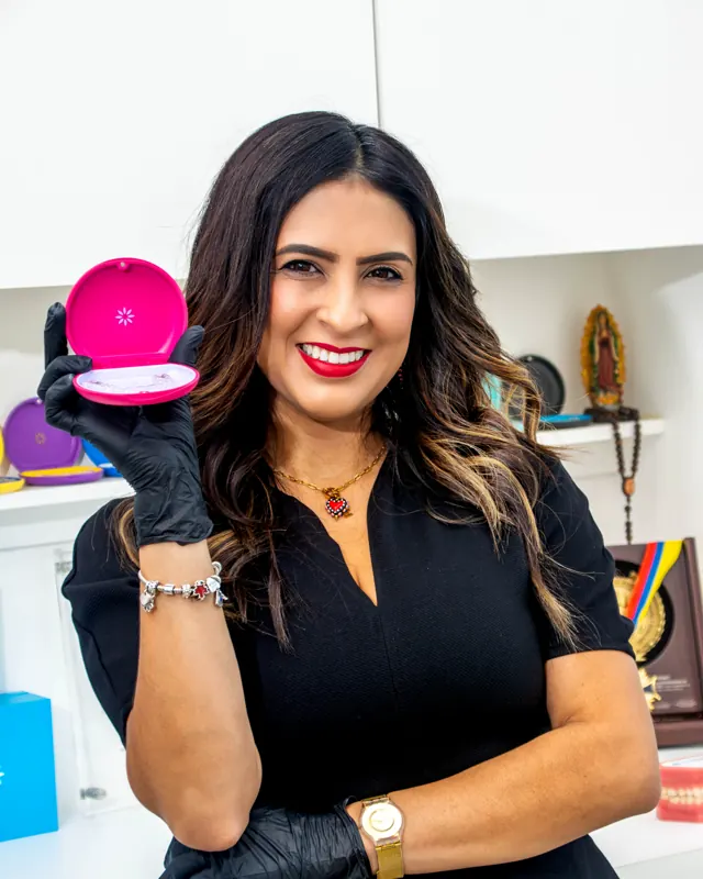 La doctora sostiene un estuche rosa de Invisalign