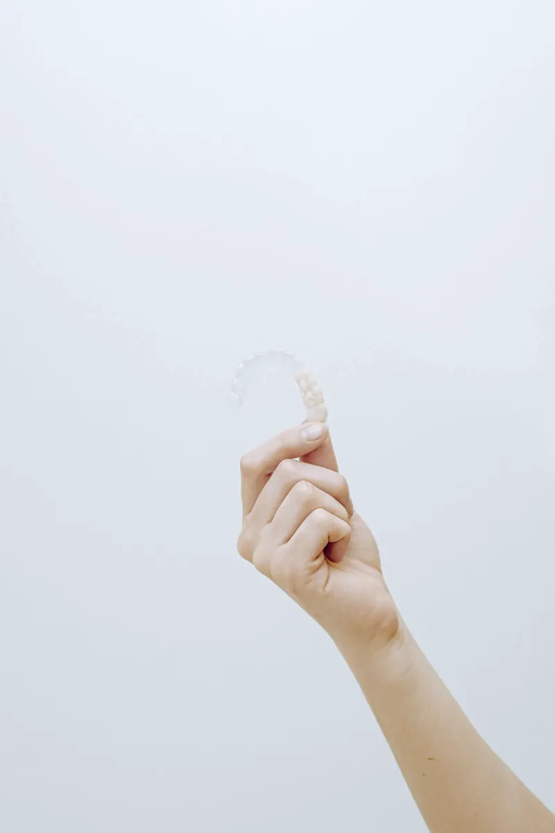 Mano sosteniendo un alineador transparente de Invisalign