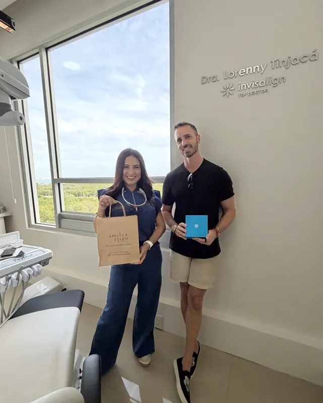 Dos pacientes con su bolsa y su caja de Invisalign, frente al ventanal del consultorio