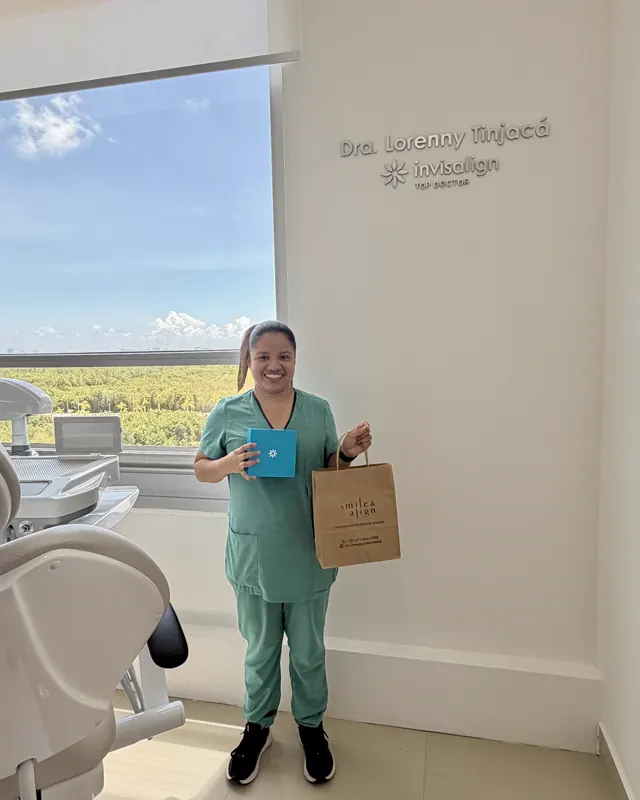 Una paciente en uniforme verde con su bolsa y su caja de Invisalign