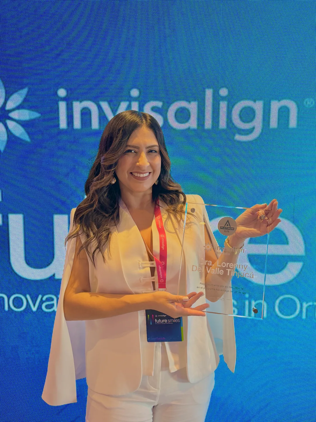 La Dra. Lorenny sonriendo con su placa de Invisalign frente a la pantalla de Future Smiles